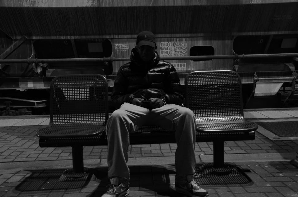 Free Image of Man Sitting on Bench at Train Station 