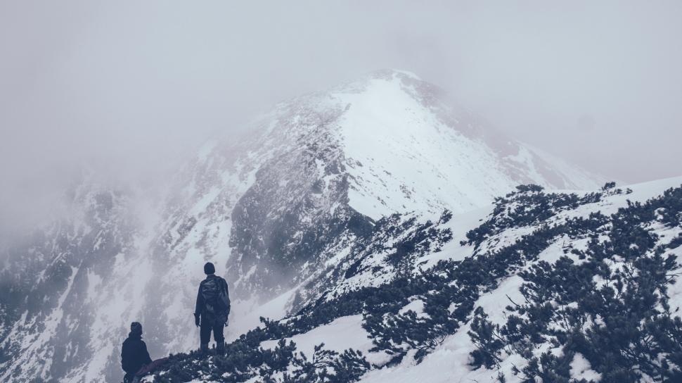 Free Image of Couple Standing on Snow-Covered Mountain 