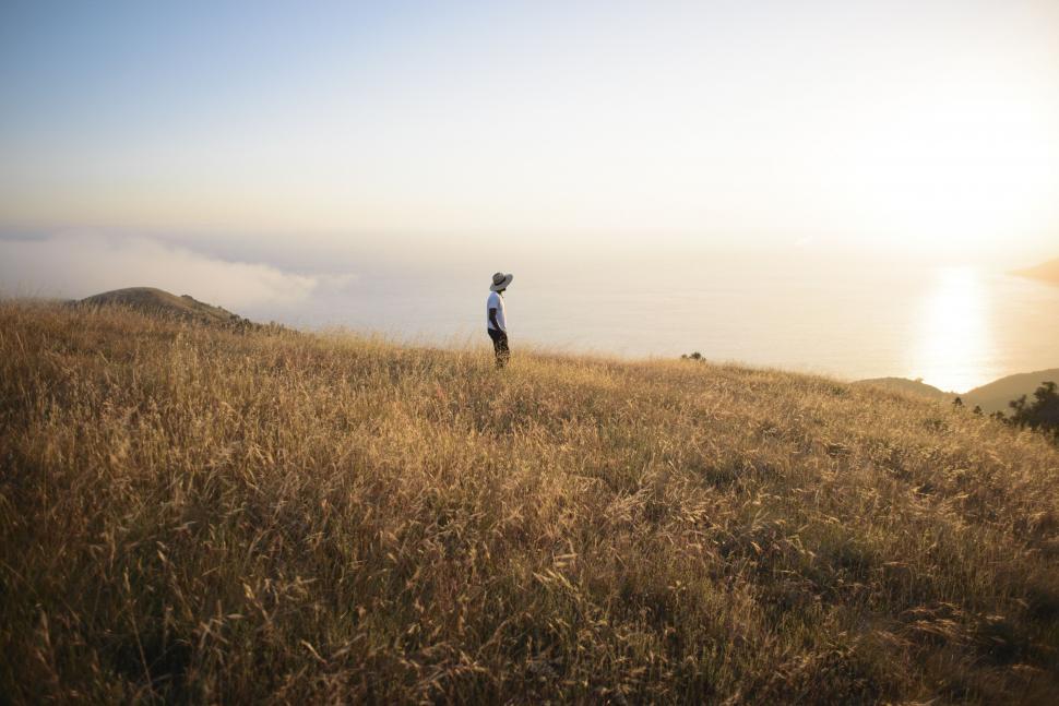 Free Image of Person Standing on Top of Grass Covered Hill 