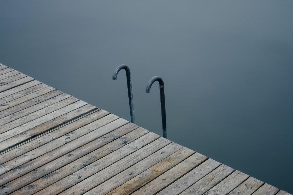 Free Image of Dock With Two Umbrella Poles in Water 