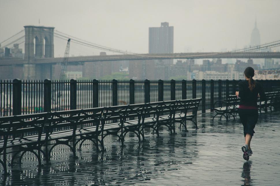 Free Image of Person Walking Across Bridge in Rain 