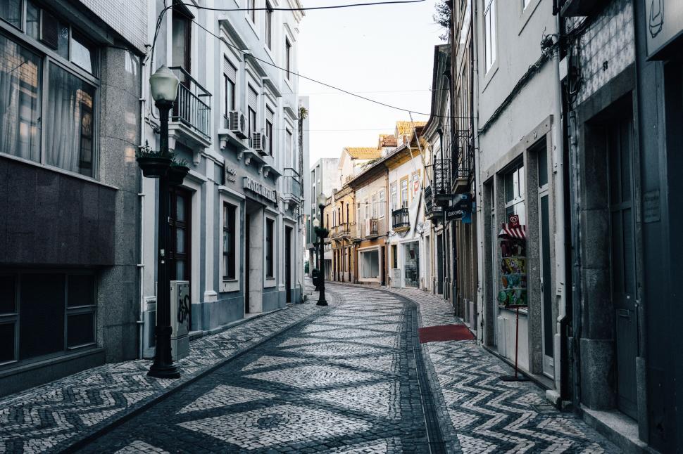 Free Image of Narrow City Street With Buildings and Cobblestones 