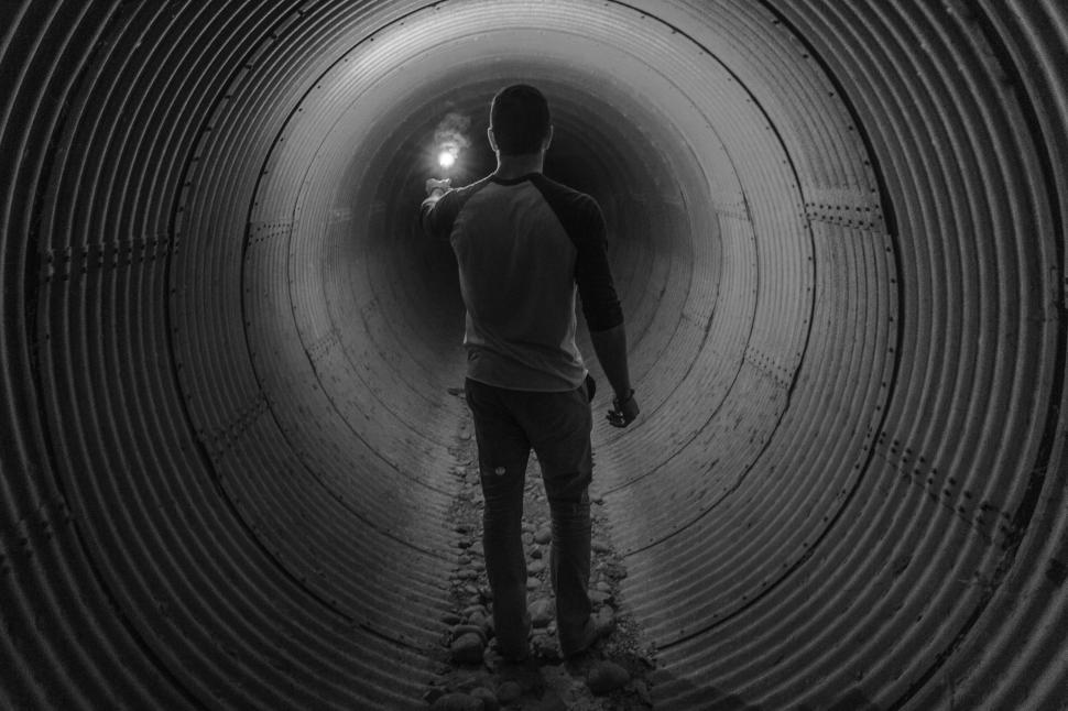 Free Image of Man Standing in the Middle of a Tunnel 