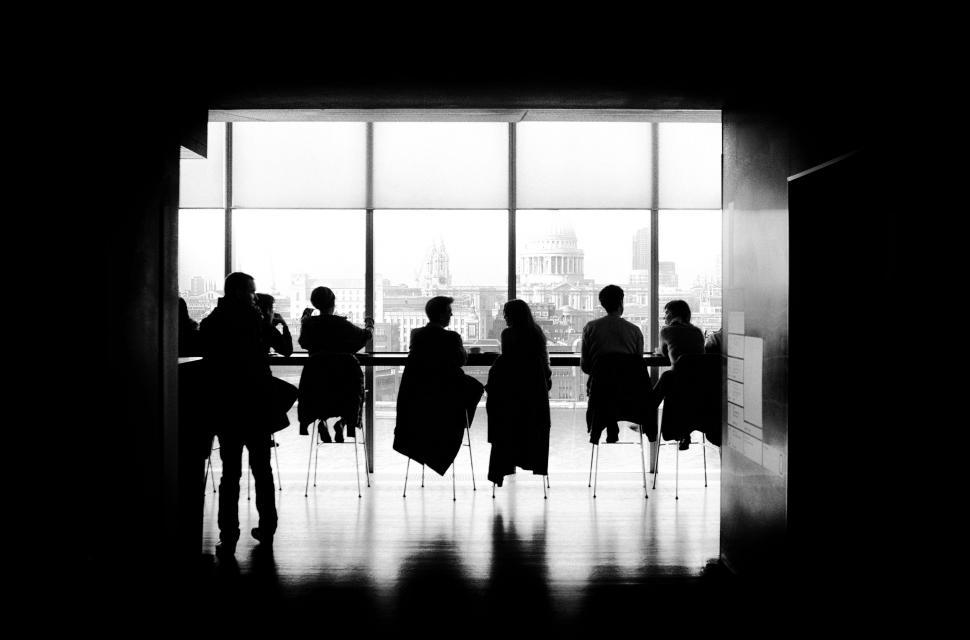 Free Image of People Sitting at a Table by a Window 