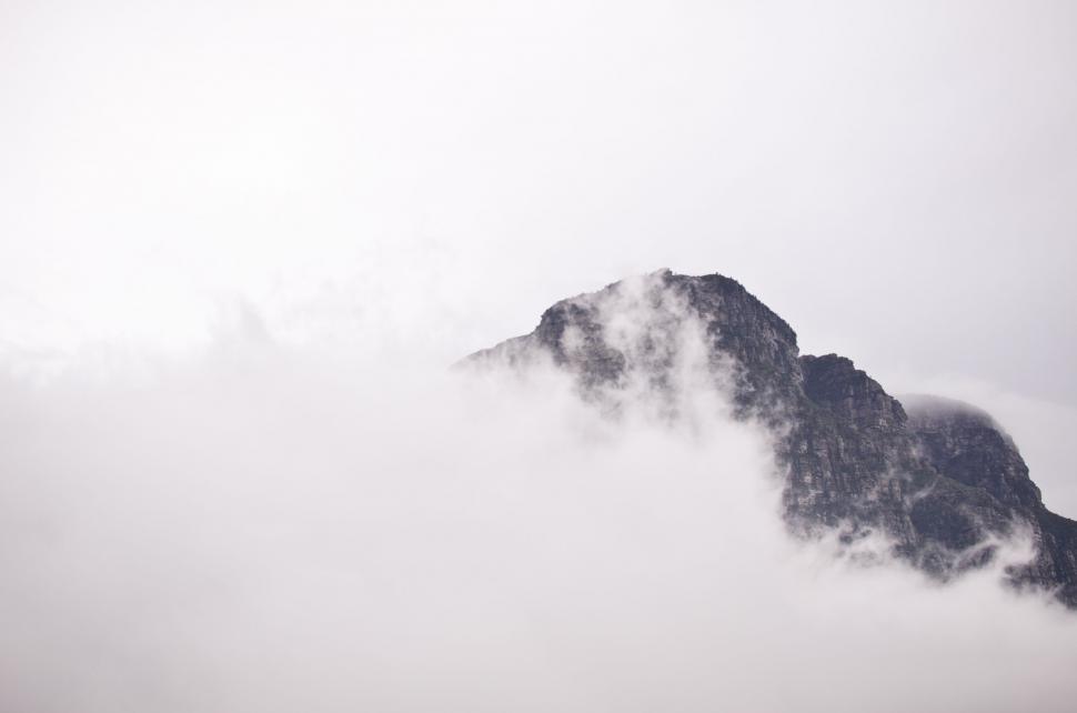 Free Image of Tall Mountain Covered in Fog on Cloudy Day 
