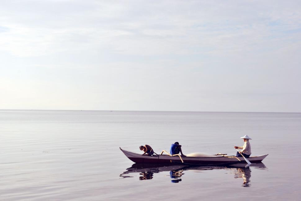 Free Image of Two People Rowing a Boat on a Large Lake 
