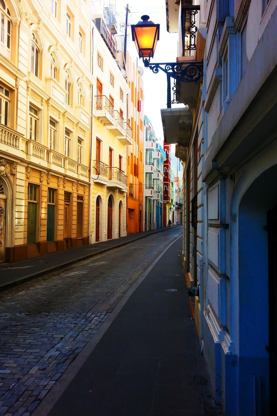 Free Image of Urban Scene: Narrow Street With Tall Buildings and Street Light 
