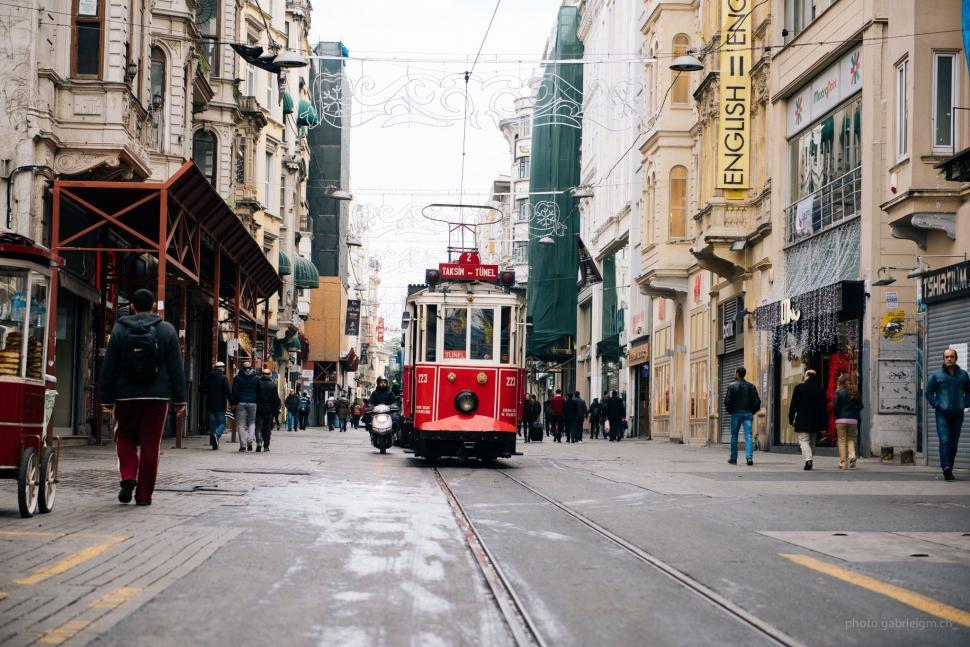 Free Image of Red Trolley Car Passing Tall Buildings 
