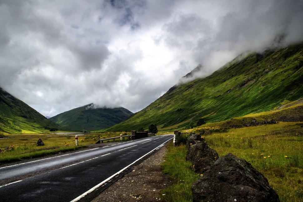 Free Image of Mountain Road Cutting Through Cloudy Sky 