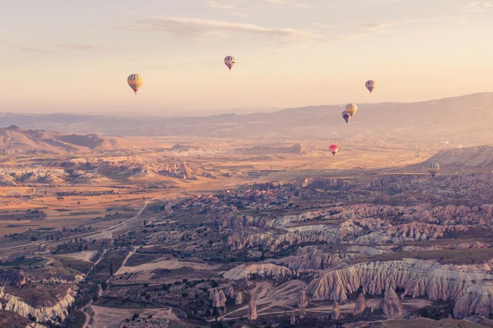 Free Image of Group of Hot Air Balloons Flying Over Valley 