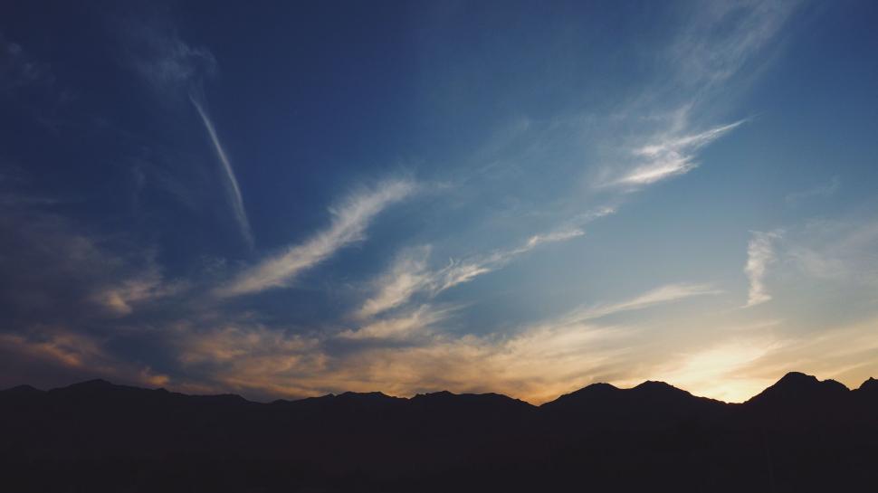 Free Image of Sun Setting Over Mountains and Clouds 
