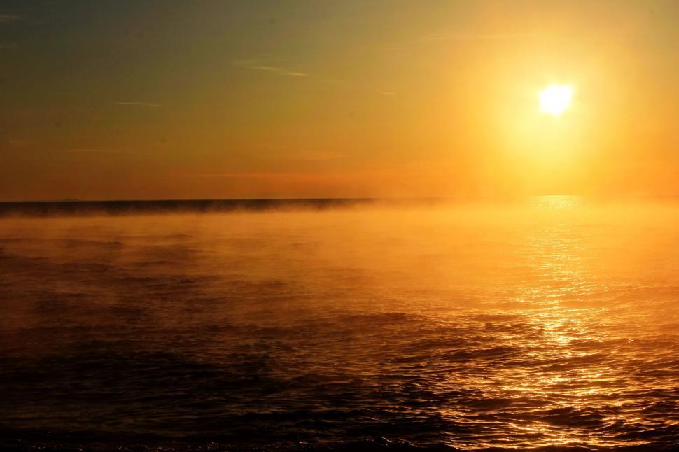 Free Image of Sun Setting Over Large Body of Water 
