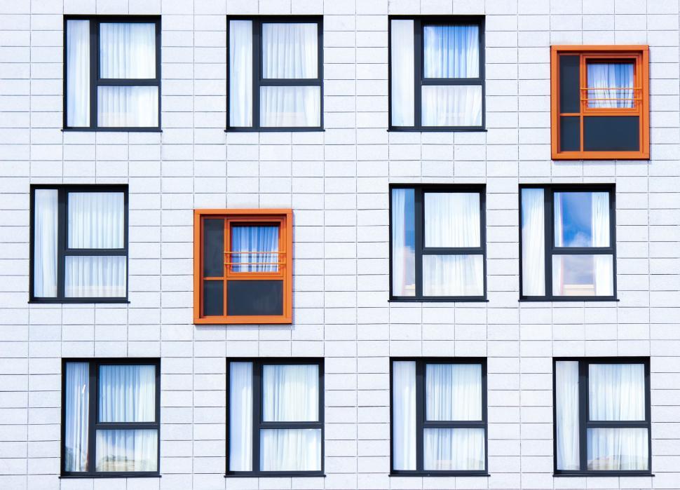 Free Image of White Building With Orange Windows and Bars 