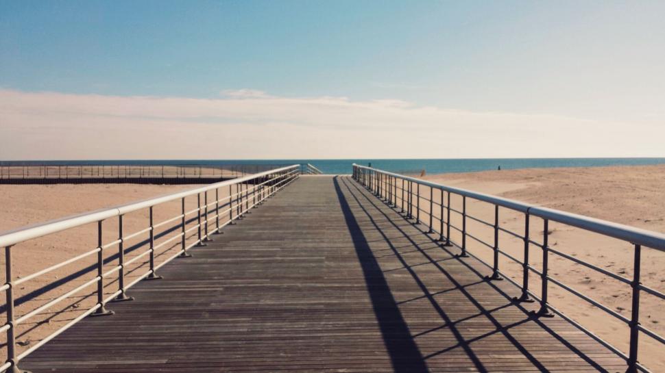 Free Image of Long Wooden Walkway Leading to Beach 