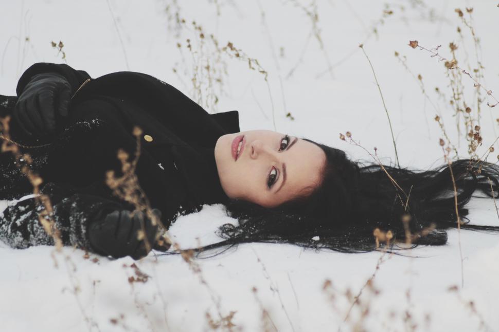 Free Image of Woman Laying in Snow in Black Dress 
