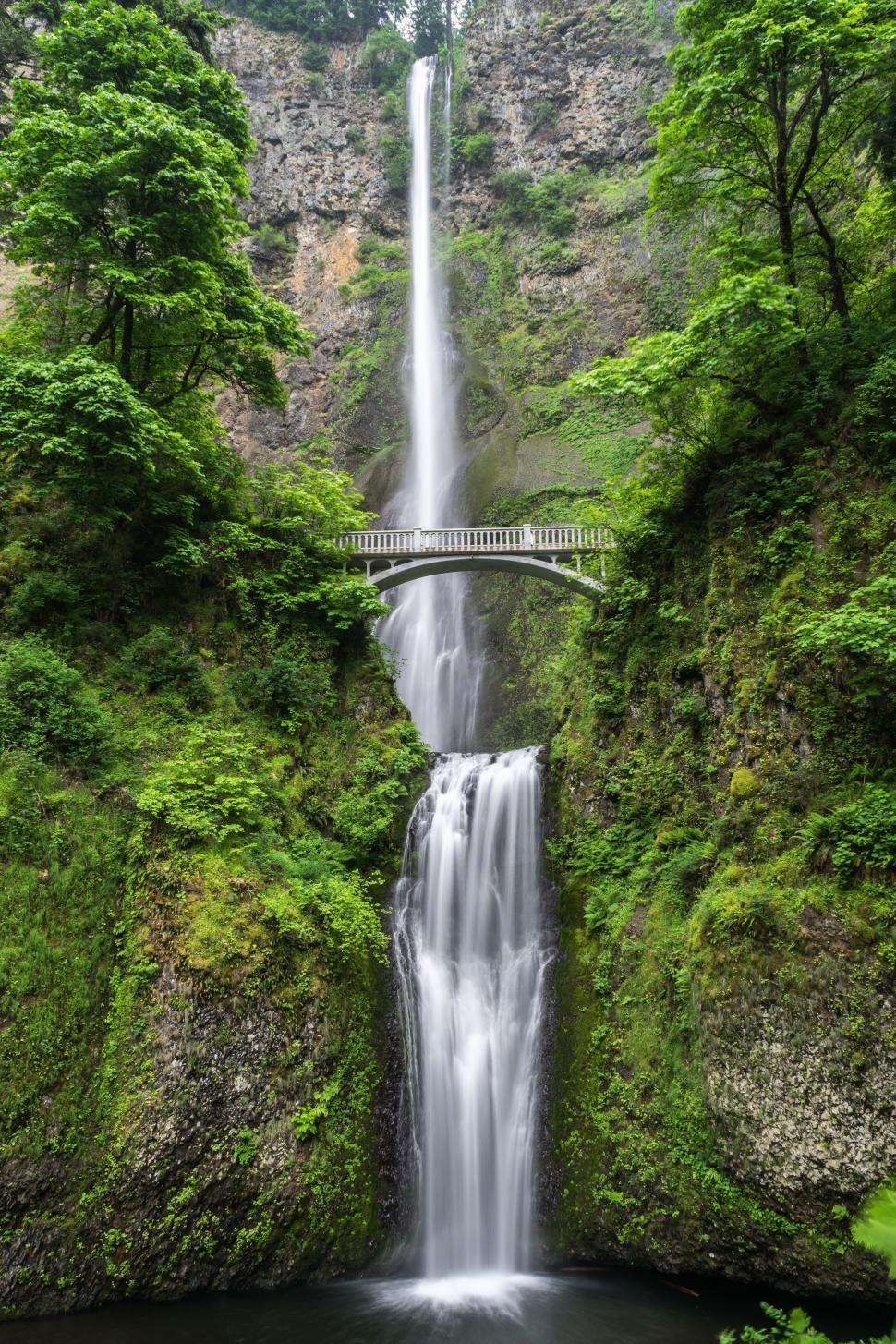 Free Image of Majestic Waterfall With Bridge Crossing 