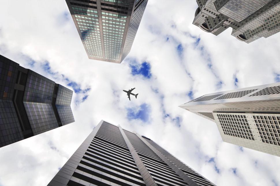 Free Image of Airplane Flying Between Tall Buildings 