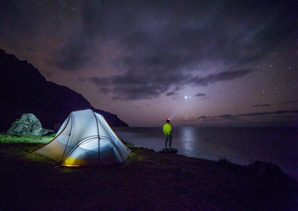 Free Image of Man Standing Next to Tent Under Night Sky 