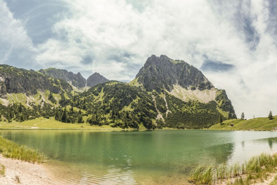Free Image of Lake Surrounded by Mountains Under a Cloudy Sky 