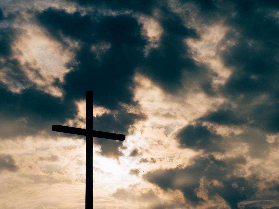 Free Image of Silhouetted Cross Against Cloudy Sky 