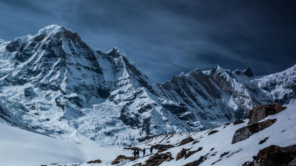 Free Image of Snow Covered Mountain Range Under Cloudy Sky 