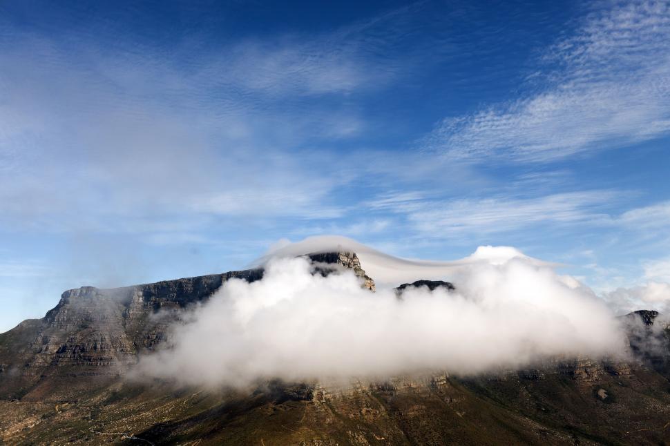 Free Image of Mountain Covered in Clouds Under Blue Sky 