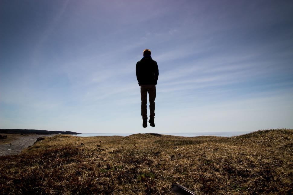 Free Image of Man Standing on Top of Grass Covered Hill 