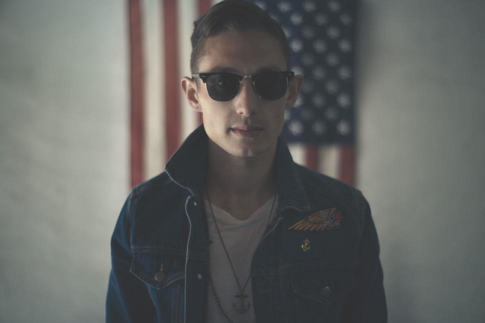 Free Image of Man Wearing Sunglasses Standing in Front of American Flag 