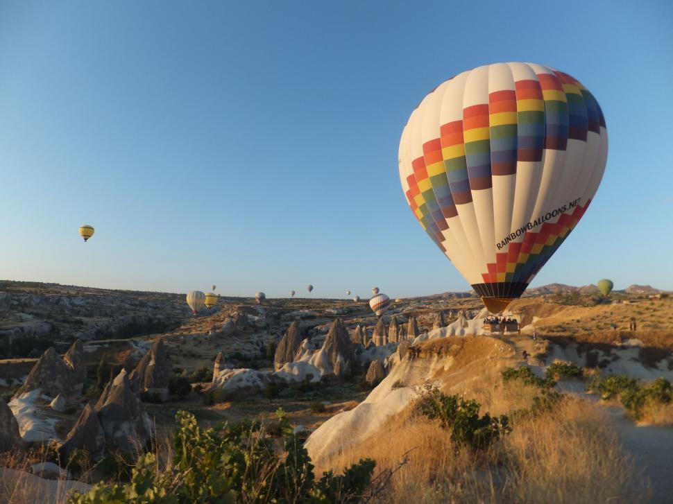 Free Image of Hot Air Balloon Flying Over Rocky Landscape 
