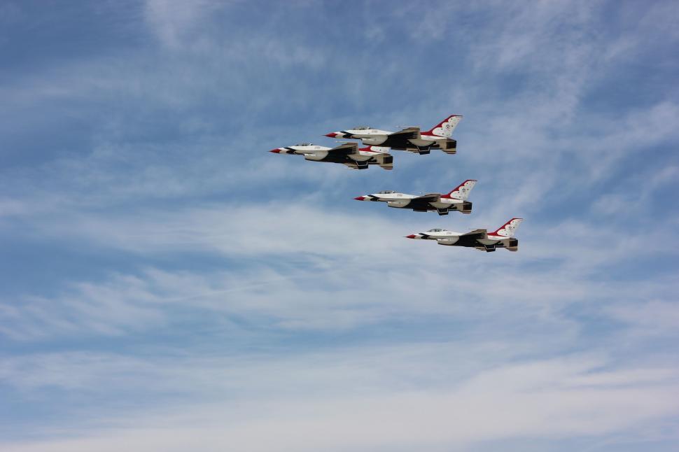 Free Image of Group of Fighter Jets Flying Through Cloudy Blue Sky 
