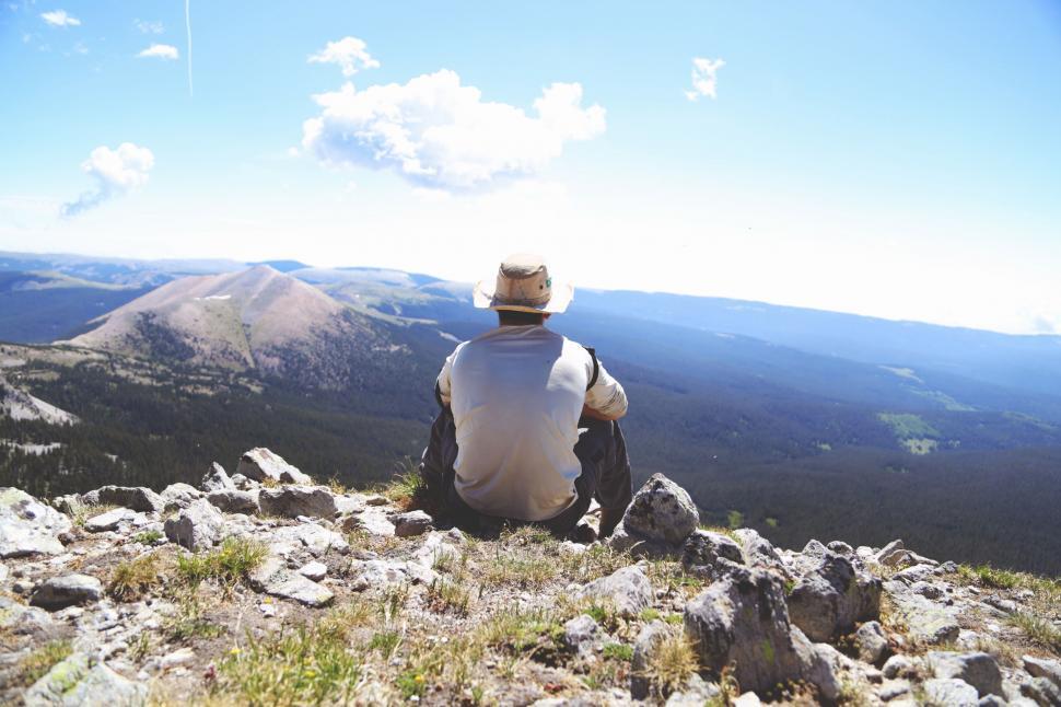 Free Image of Man Sitting on Mountain Overlooking Valley 