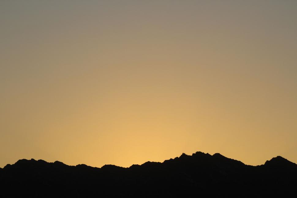 Free Image of Bird Flying Over Mountain at Sunset 