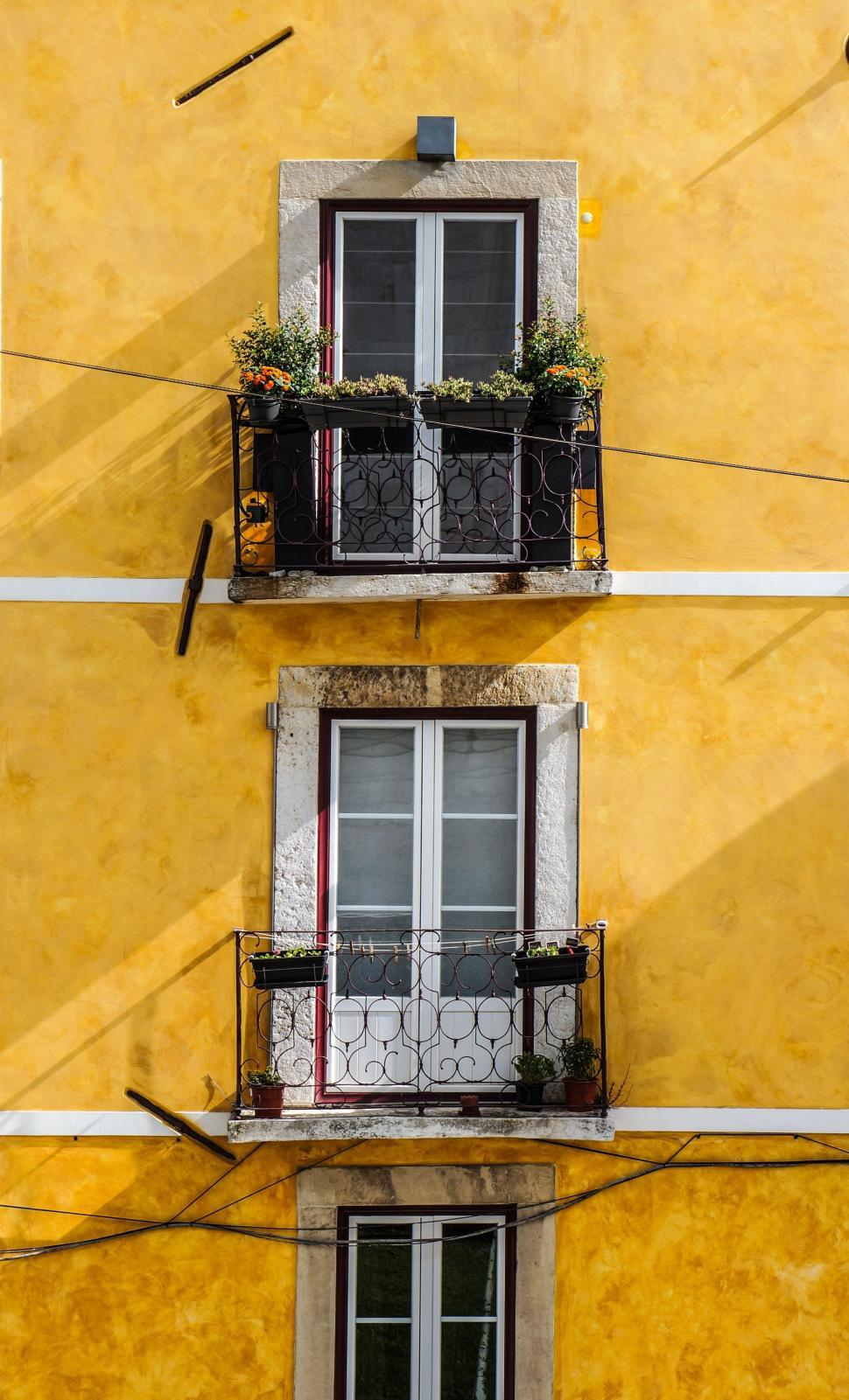 Free Image of Yellow Building With Two Balconies and Two Windows 