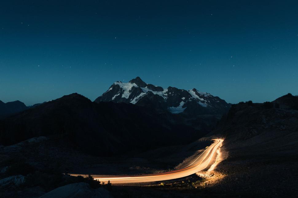Free Image of Car Driving Down Mountain Road at Night 