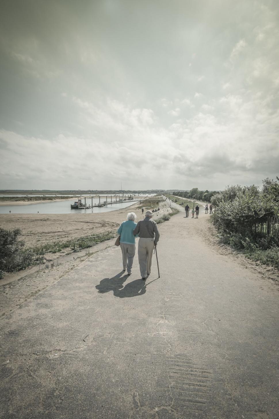 Free Image of Two People Walking Down a Dirt Road 