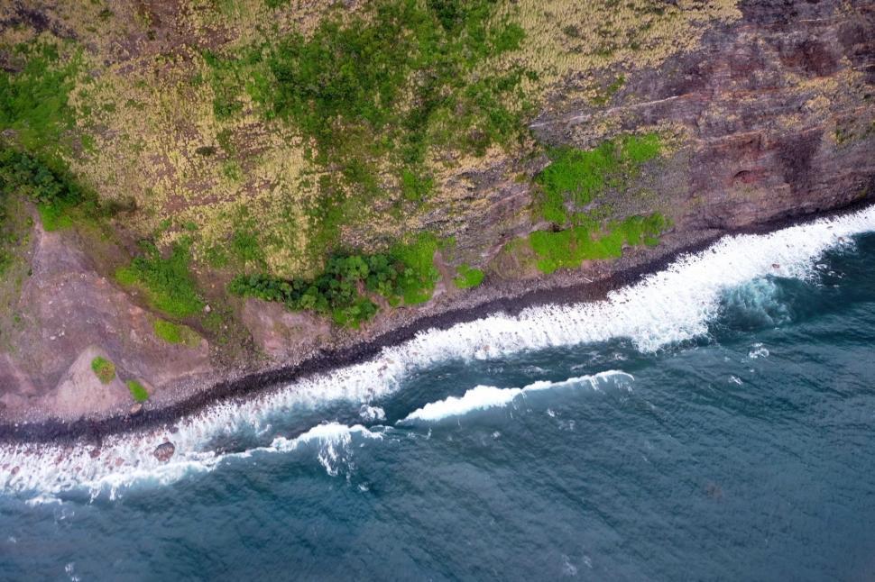 Free Image of Aerial View of Lush Green Hillside Next to Ocean 