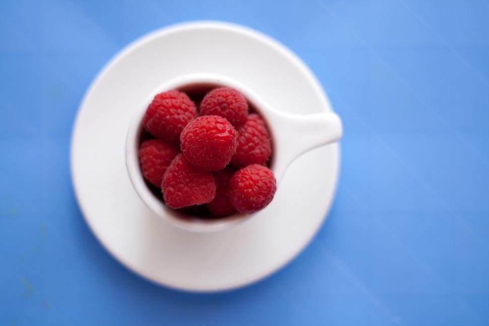 Free Image of White Bowl Filled With Raspberries on Blue Table 