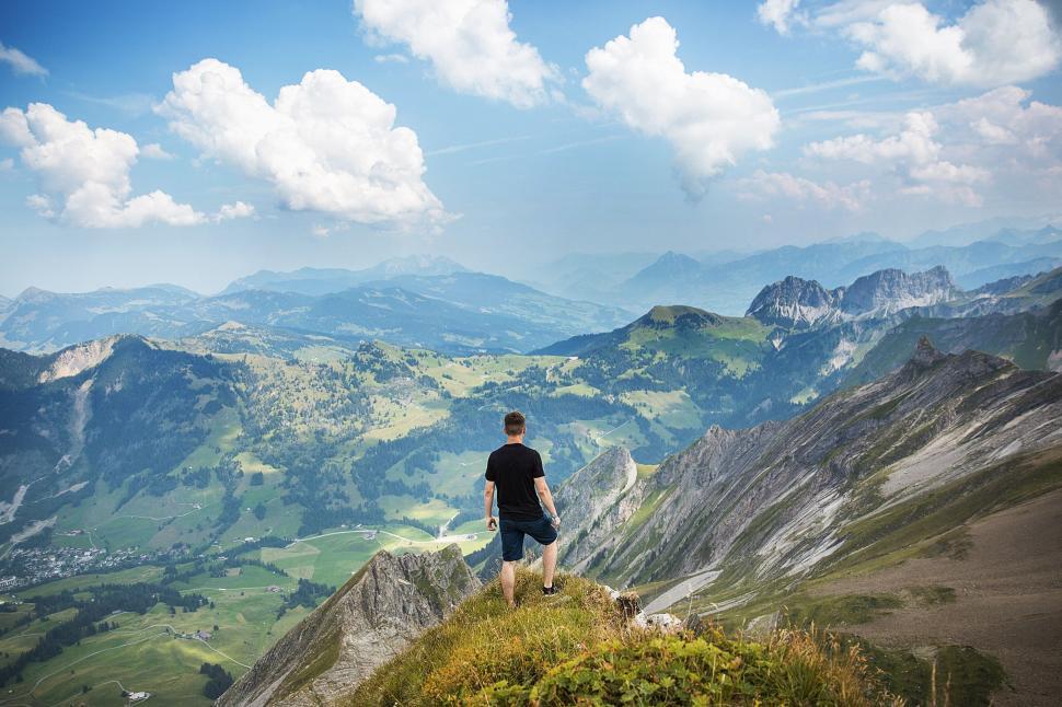 Free Image of Man Standing on Top of Lush Green Hillside 
