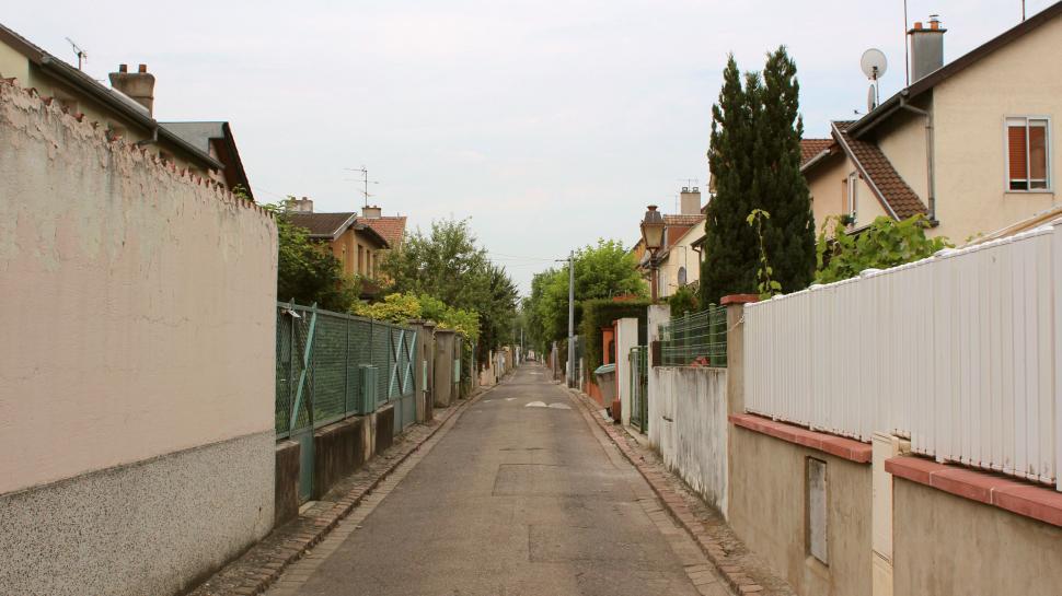Free Image of Narrow Street With Fenced-In Area Between Two Buildings 