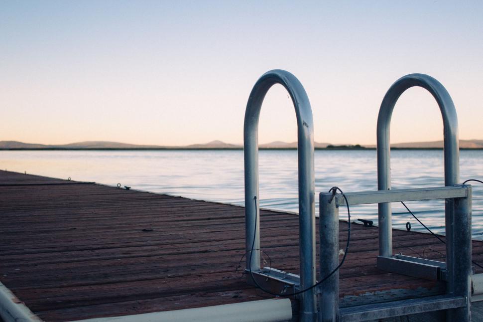 Free Image of Wooden Dock With Two Metal Railings by the Water 