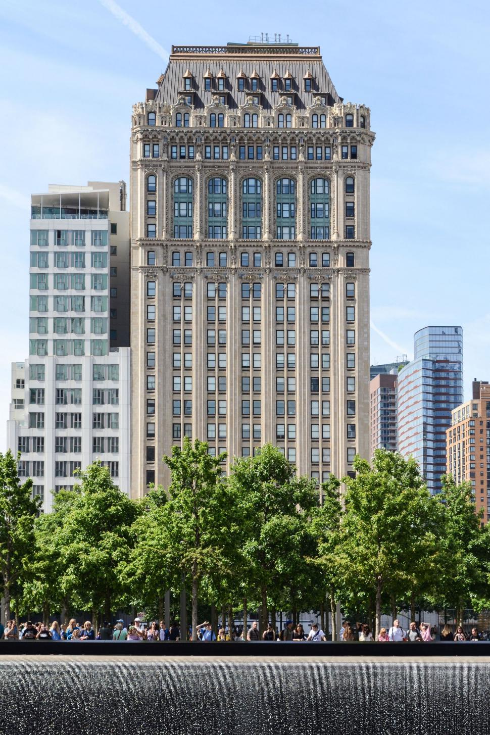 Free Image of Modern Skyscraper With Trees in Front 