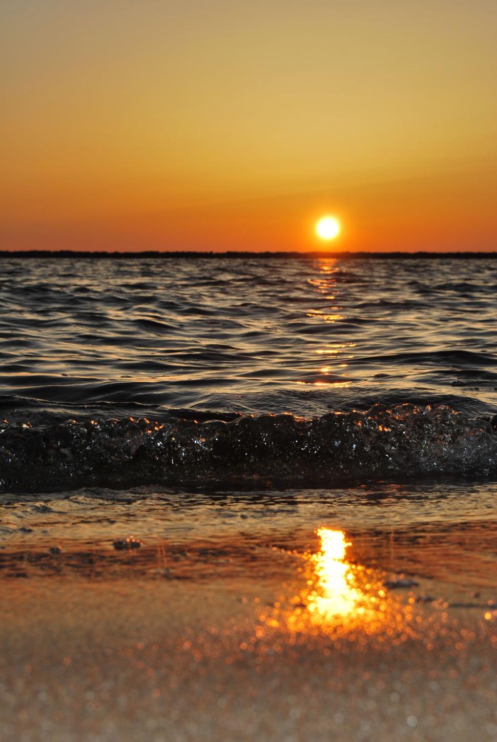 Free Image of Sun Setting Over Water at Beach 