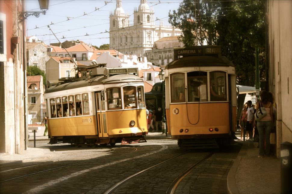 Free Image of Yellow Trolleys Driving Down a Street 
