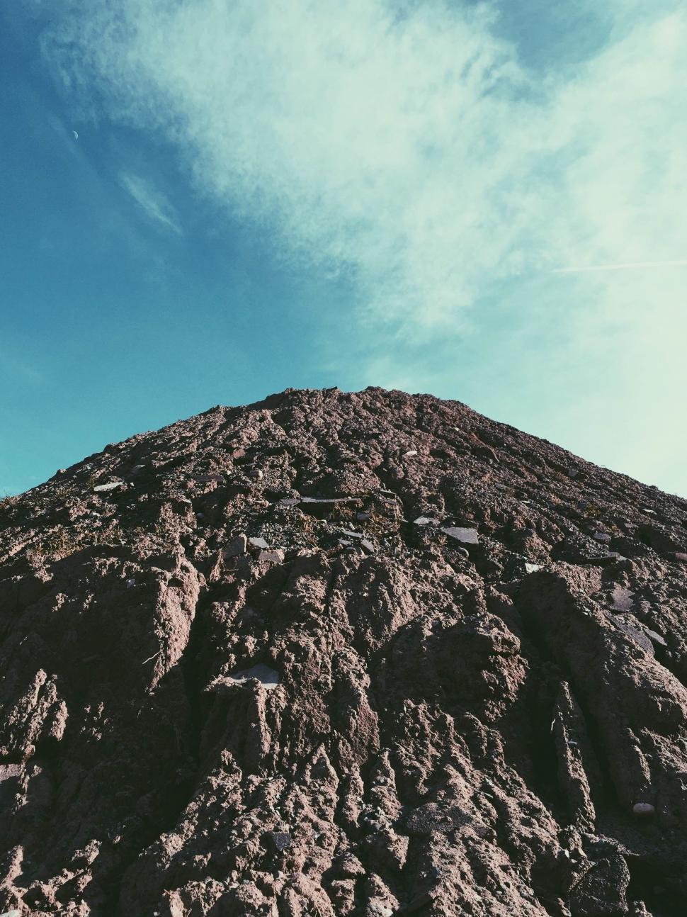 Free Image of Large Mound of Dirt Under Blue Sky 