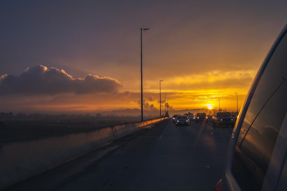 Free Image of Sun Setting Over Highway With Cars 