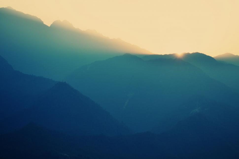Free Image of Bird Soaring Over Mountain Range at Sunset 