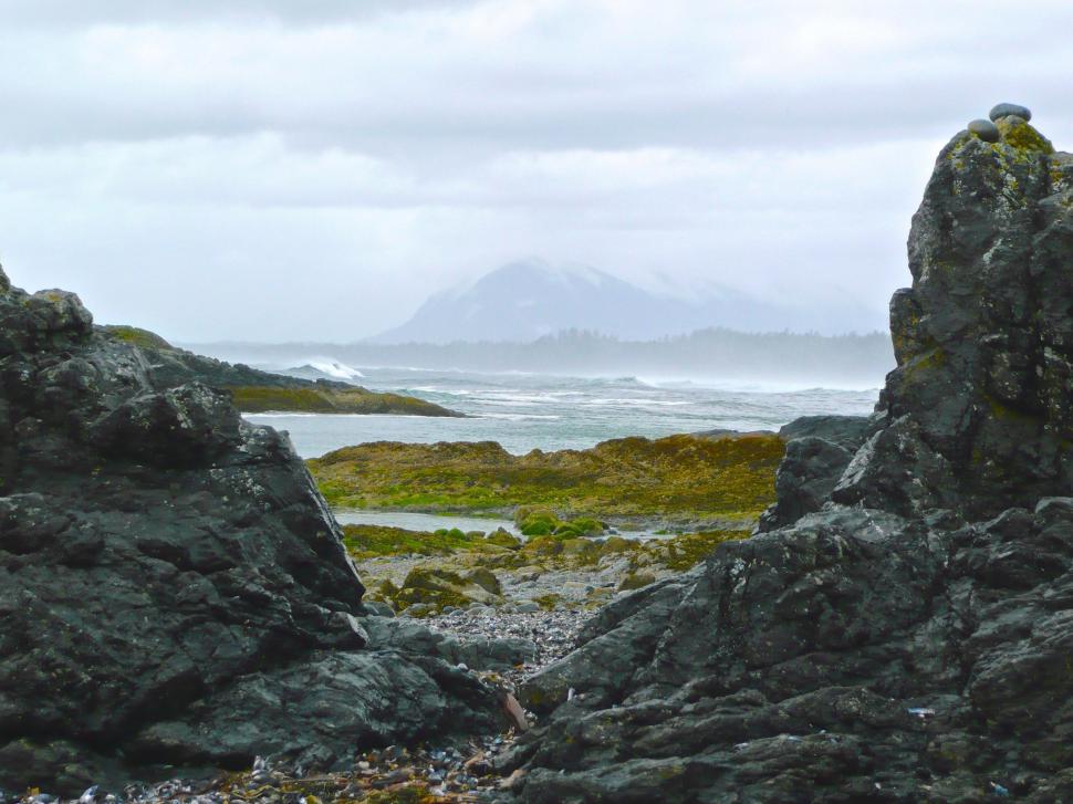 Free Image of Rocky Beach With Distant Mountain 