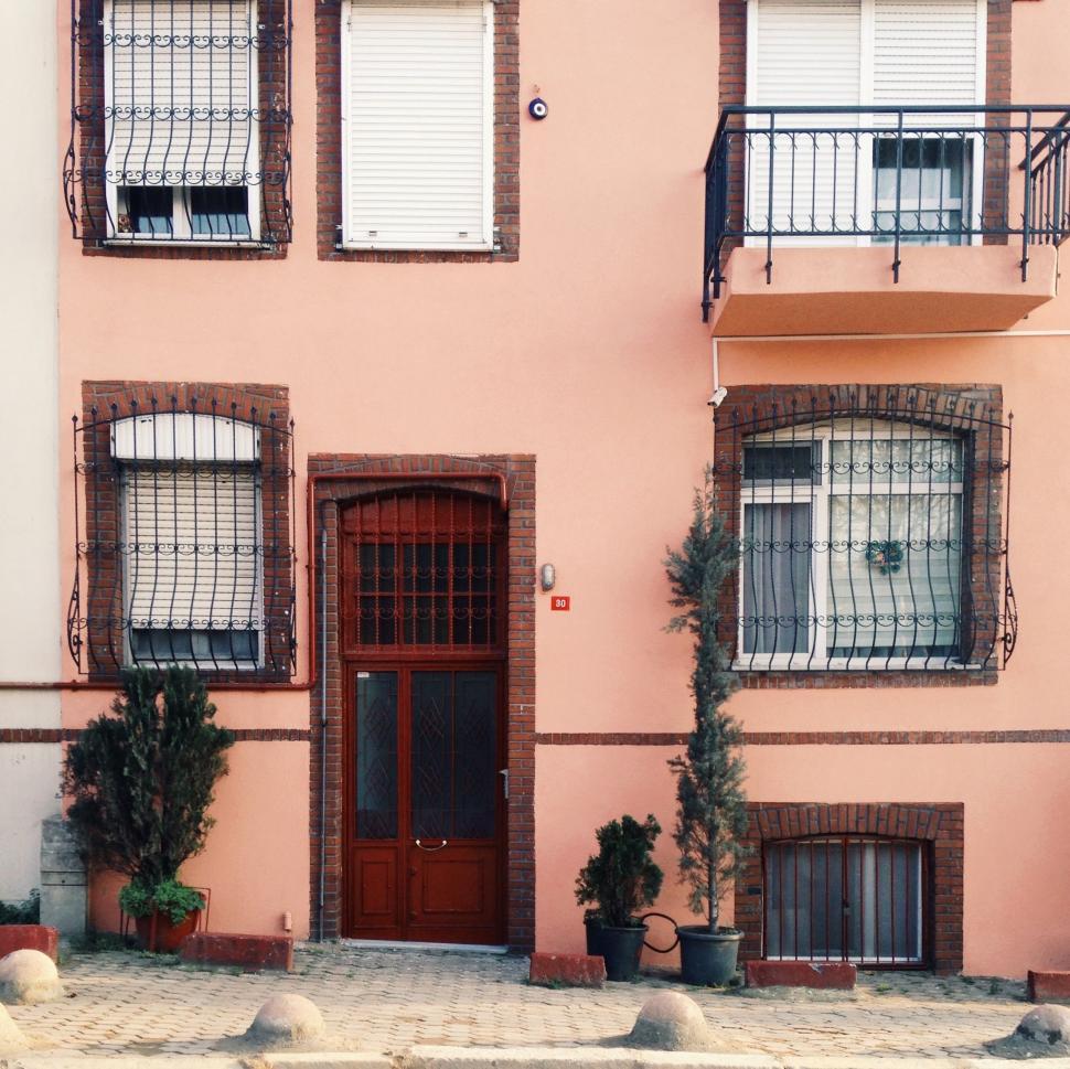 Free Image of Pink Building With Red Door and Windows 