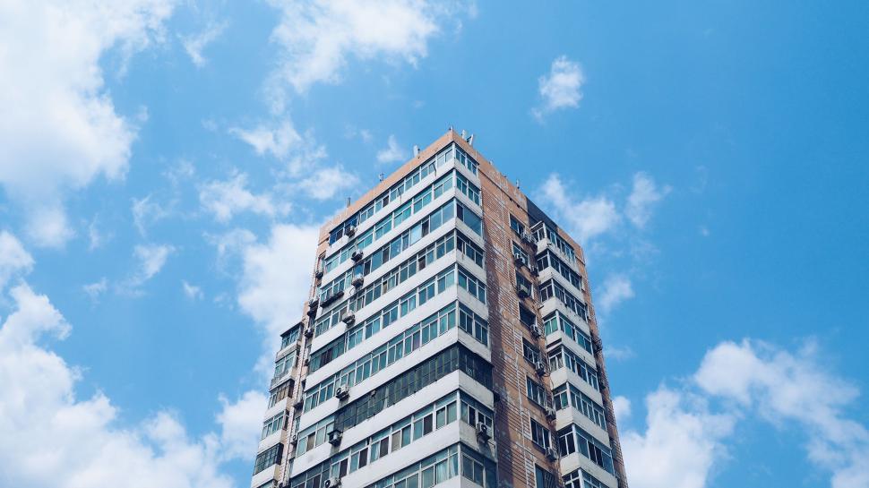 Free Image of Tall Building With Numerous Windows Under Blue Sky 