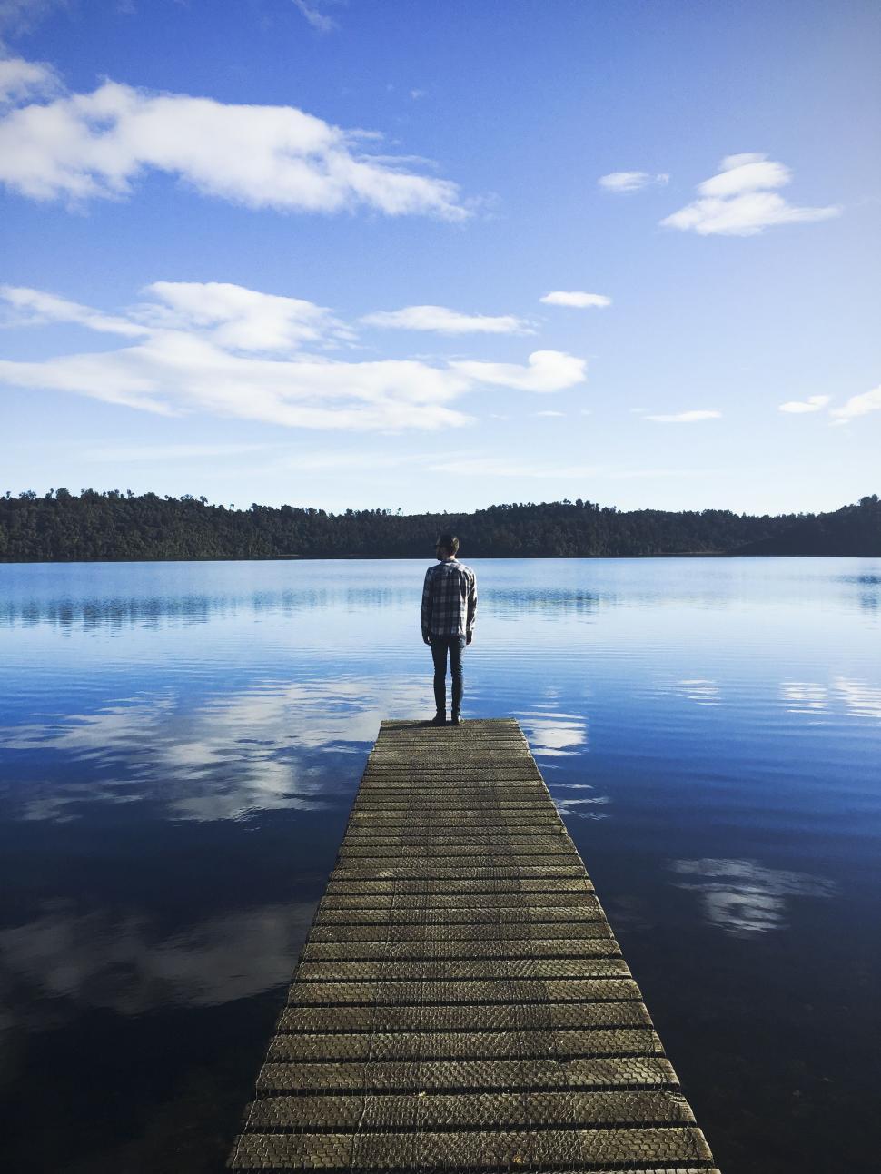 Free Image of Person Standing on Dock in Middle of Lake 